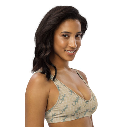 Woman wearing beige bikini top with pattern of green geckos.