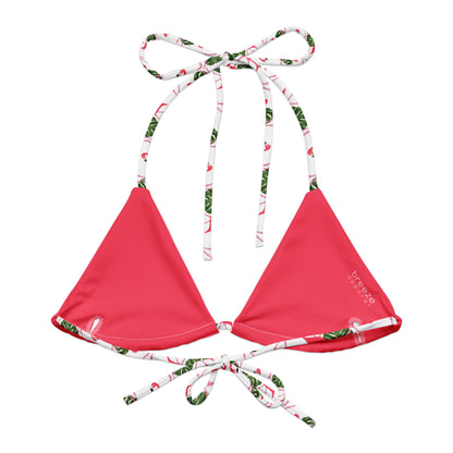 Back of bikini top with pattern of flamingos set on a white background. Interior is pink.