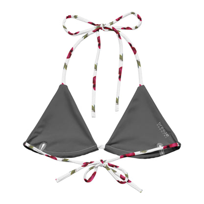 Back of bikini top with all-over pattern of cherries set on a white background.