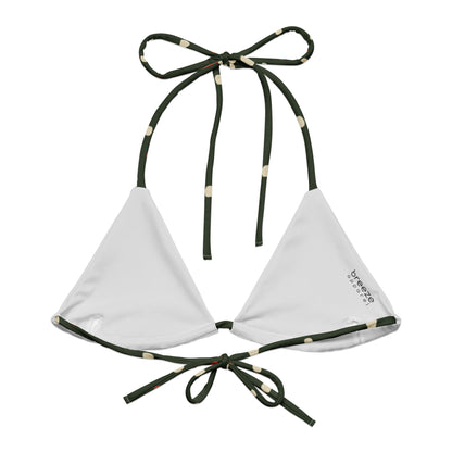 Back of bikini top with pattern of mushrooms set on a forest-green background. Interior is light gray.
