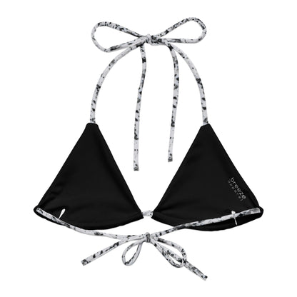 Back of bikini top with design of black splotches on a white background. Interior is black.