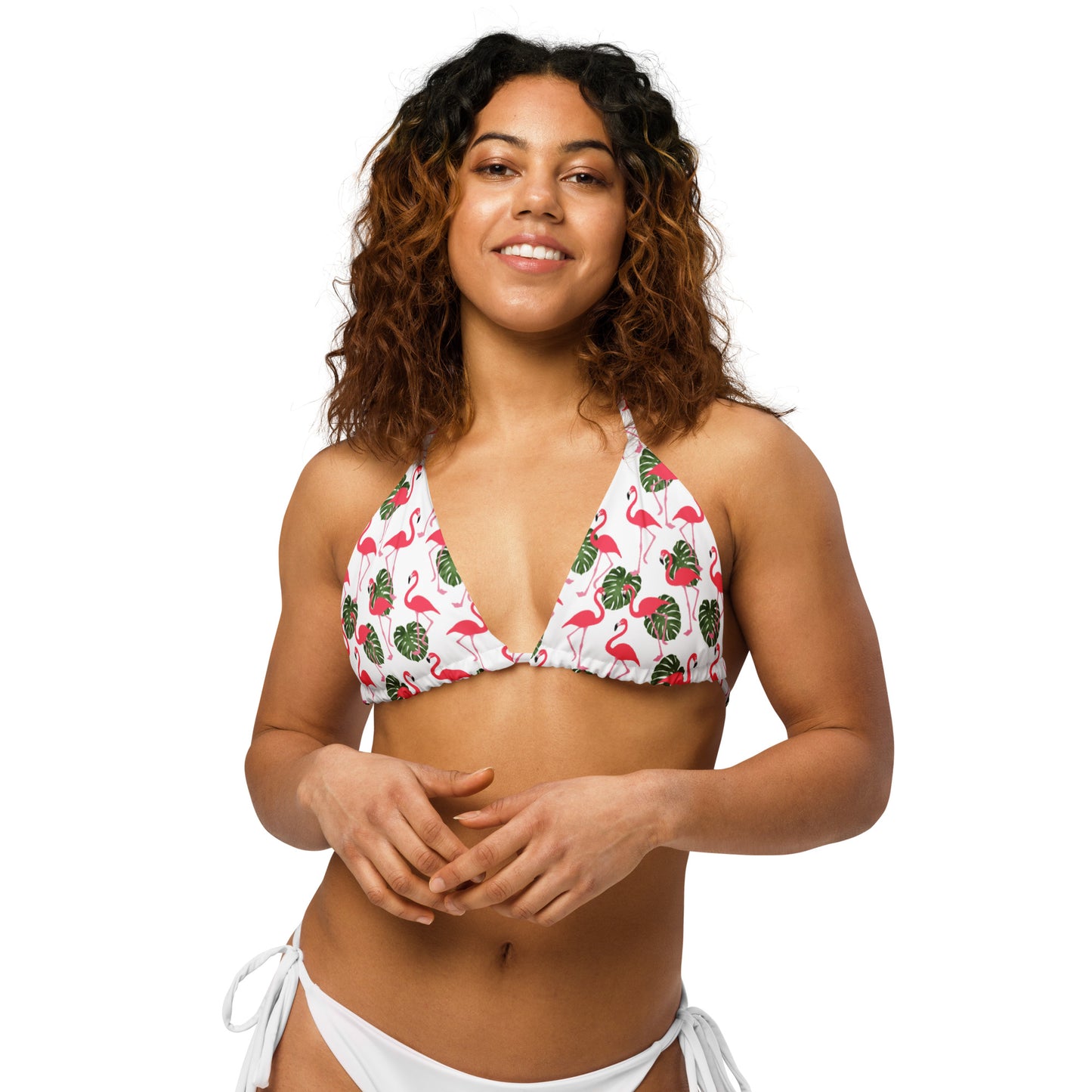 Woman wearing bikini top with pattern of flamingos set on a white background.