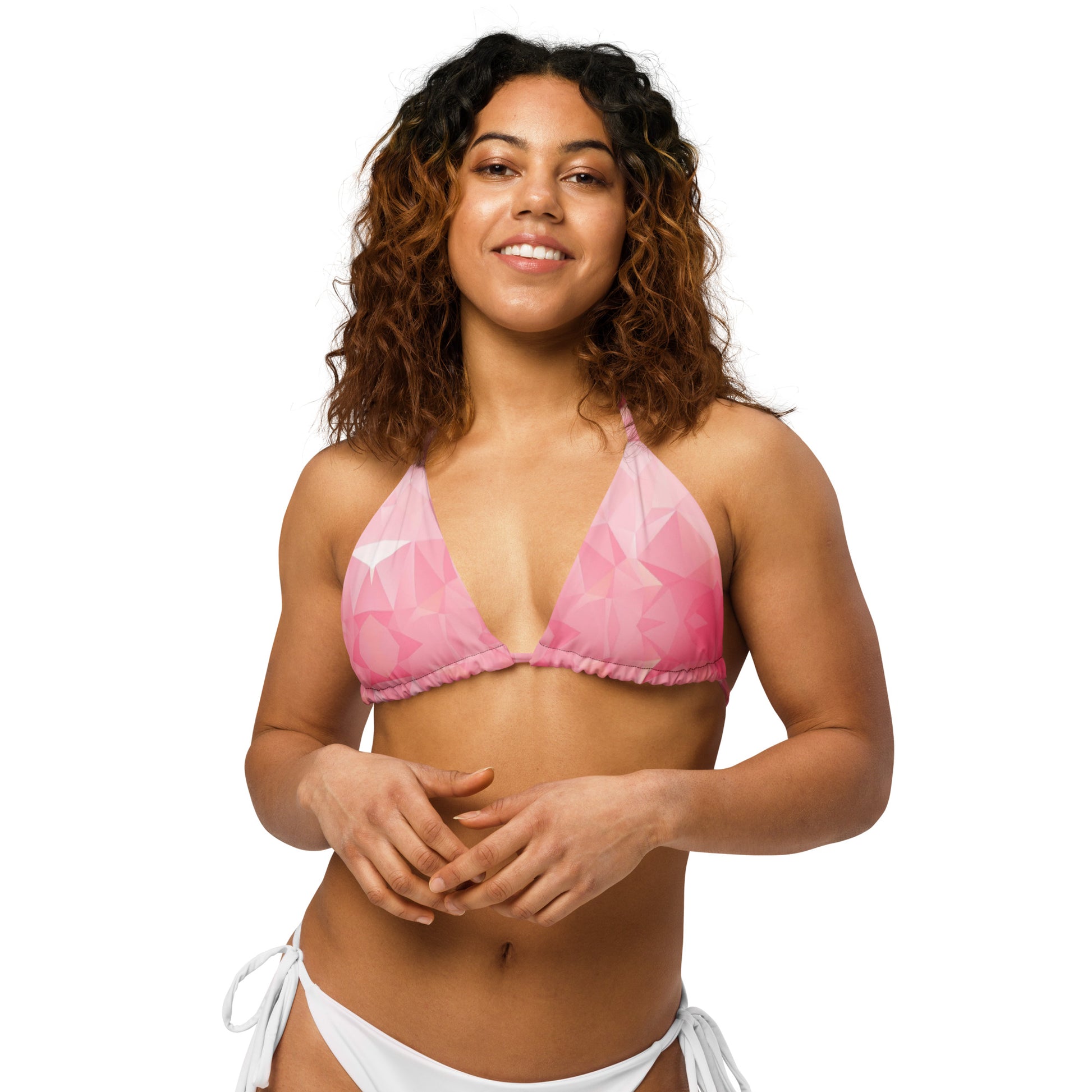 Woman wearing bikini top with pink geometric pattern.