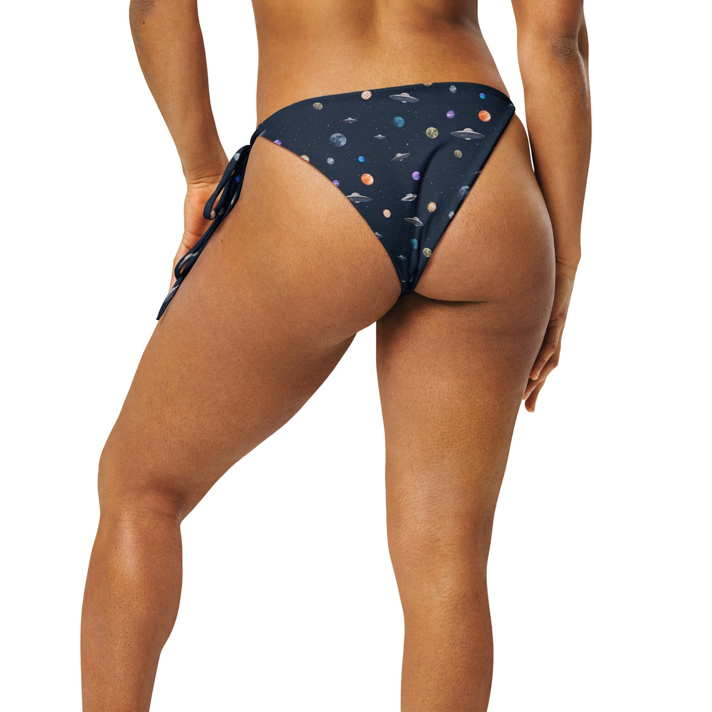 Woman wearing string bikini bottom with pattern of UFOs and planets in space.