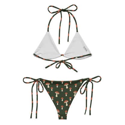 Back of bikini with pattern of mushrooms set on a forest-green background. Interior is light gray.
