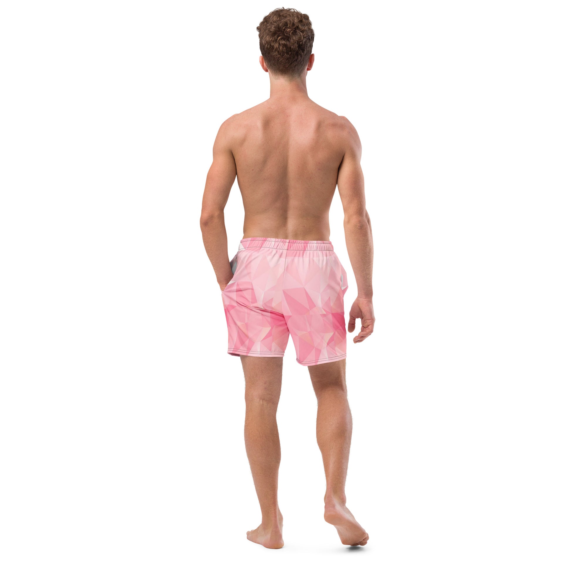 Rear view of man wearing swim trunks with pink geometric pattern.