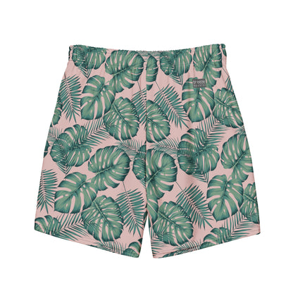 Back of swim trunks with pattern of green palm leaves set on a pink background.