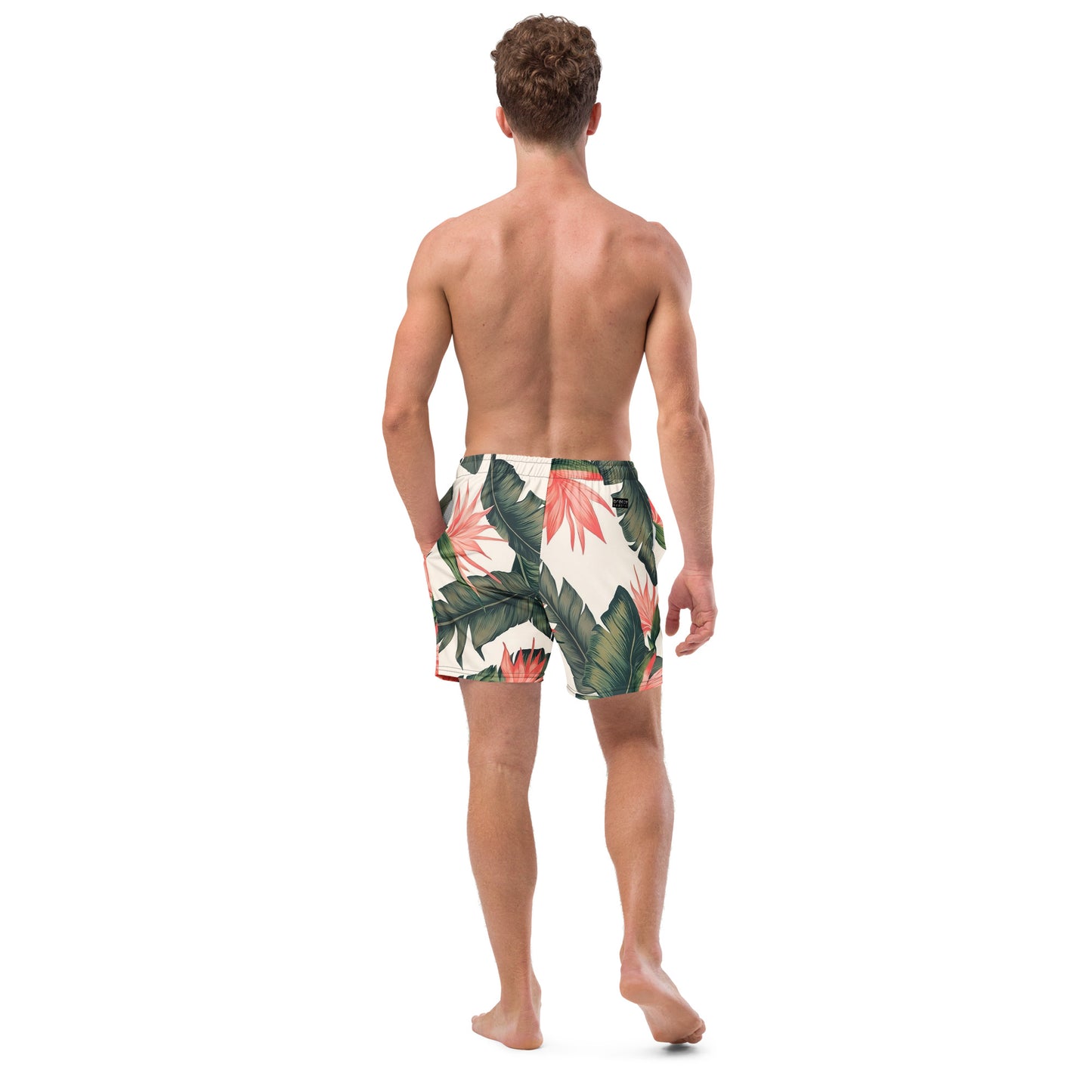 Man wearing swim trunks with tropical floral pattern.