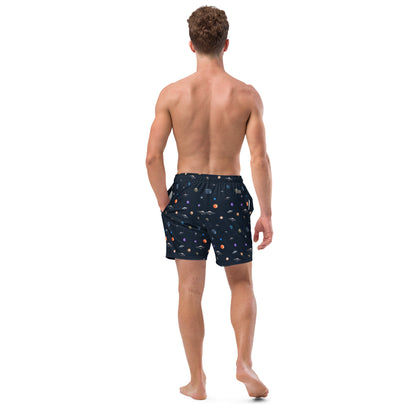Man wearing swim trunks with graphic of planets and UFOs in space.