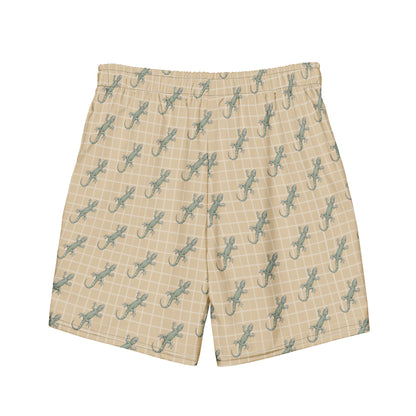 Beige swim trunks with pattern of green lizards.