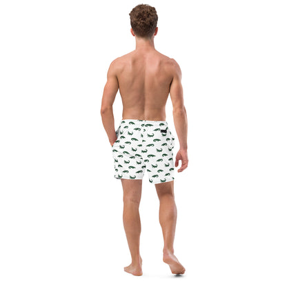 Man wearing white swim trunks with pattern of green alligators.
