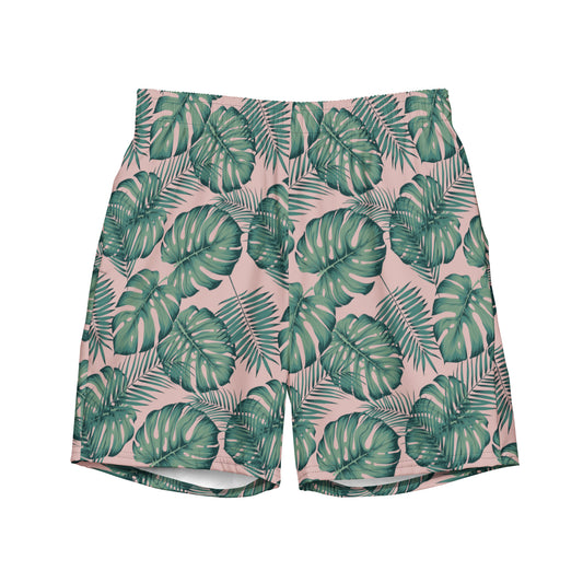 Swim trunks with pattern of green palm leaves set on a pink background.