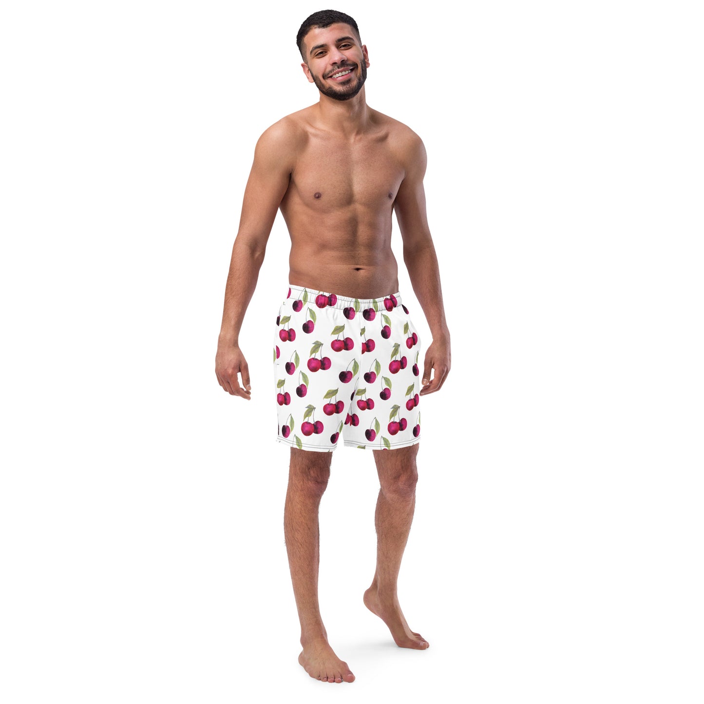 Man wearing swim trunks with pattern of cherries set on a white background.