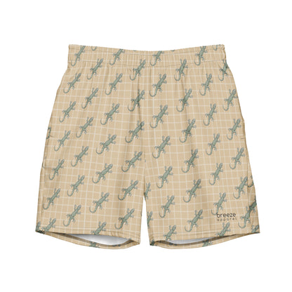 Beige swim trunks with pattern of green lizards.