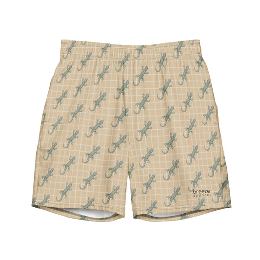 Beige swim trunks with pattern of green lizards.