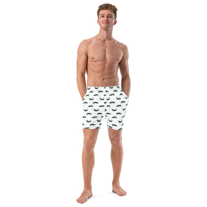 Man wearing white swim trunks with pattern of green alligators.
