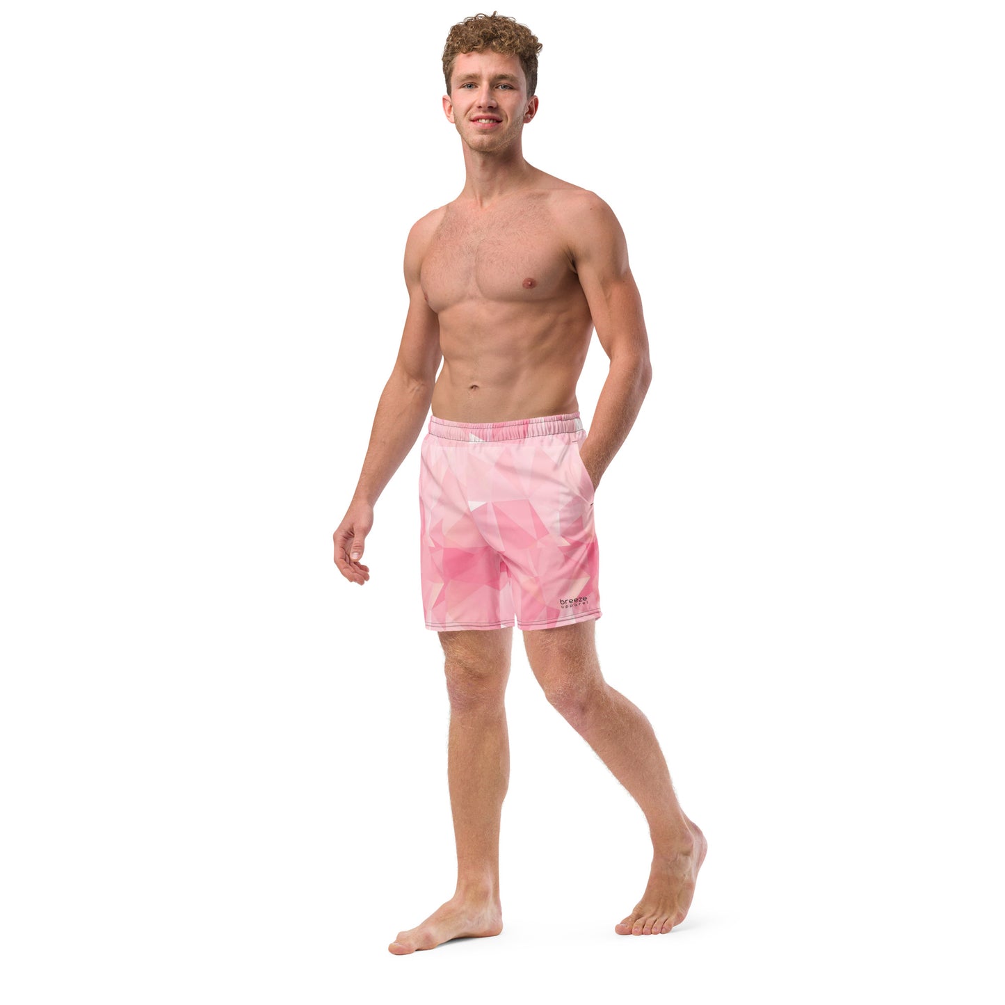 Man wearing swim trunks with pink geometric pattern.