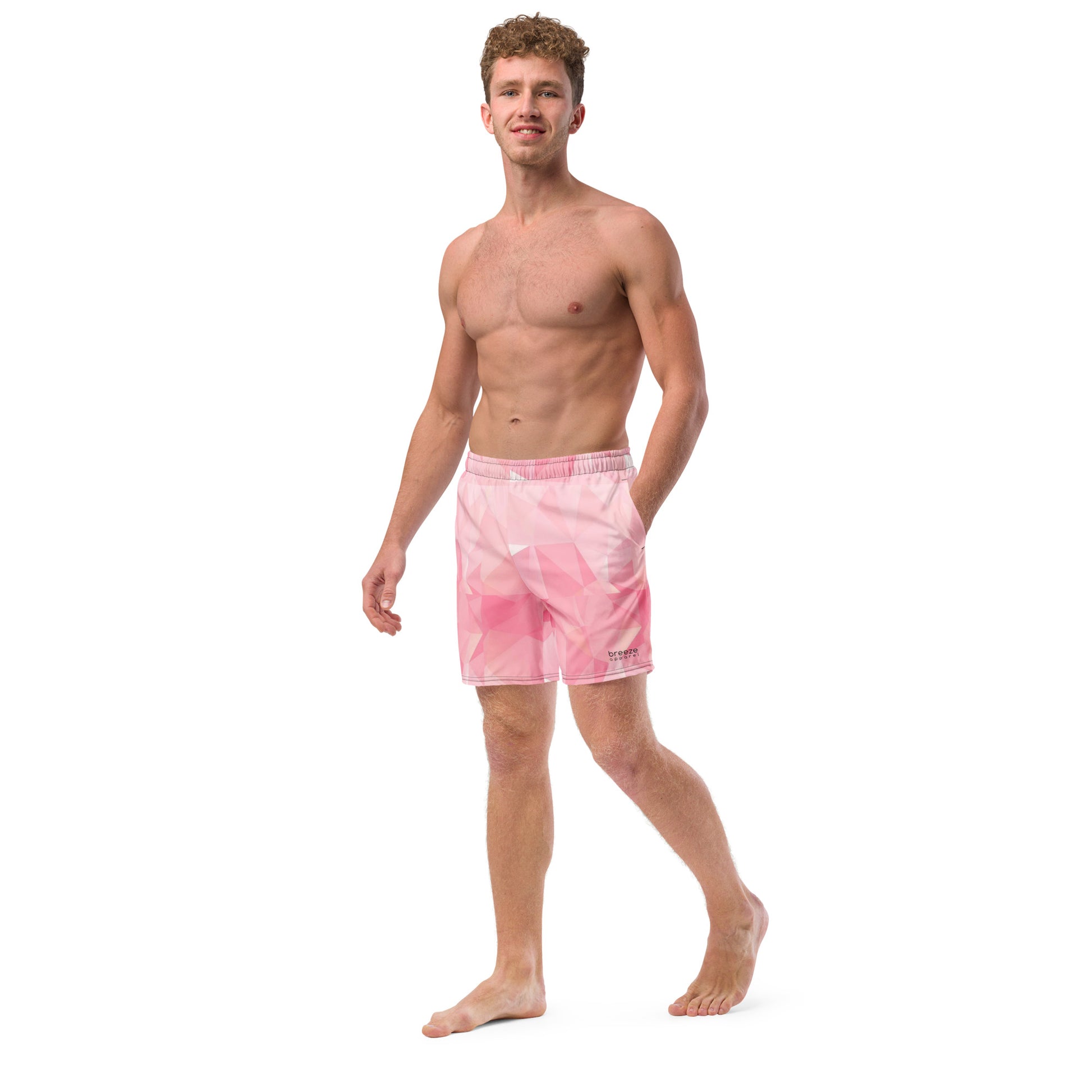 Man wearing swim trunks with pink geometric pattern.
