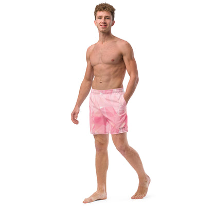 Man wearing swim trunks with pink geometric pattern.