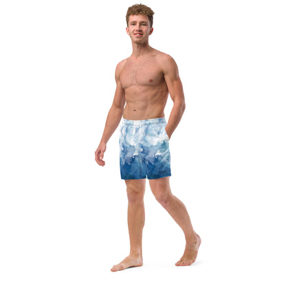 Man wearing swim trunks with a blue-white watercolor pattern.