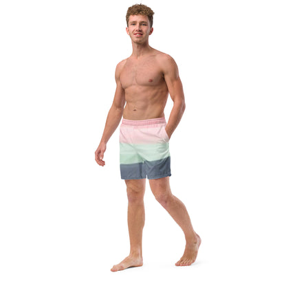 Man wearing swim trunks with color scheme of pink, light green, and gray, resembling watercolor.