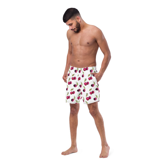 Man wearing swim trunks with pattern of cherries set on a white background.