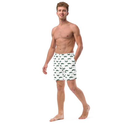 Man wearing white swim trunks with pattern of green alligators.