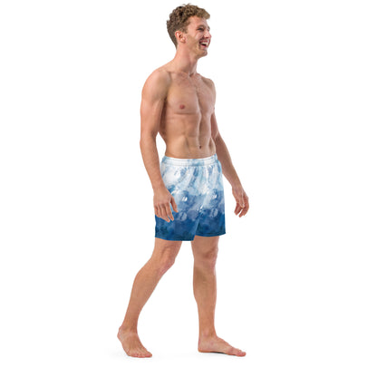 Man wearing swim trunks with a blue-white watercolor pattern.
