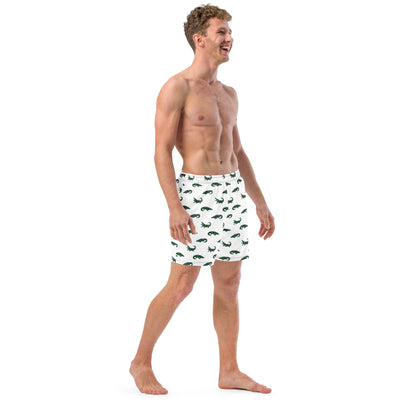 Man wearing white swim trunks with pattern of green alligators.