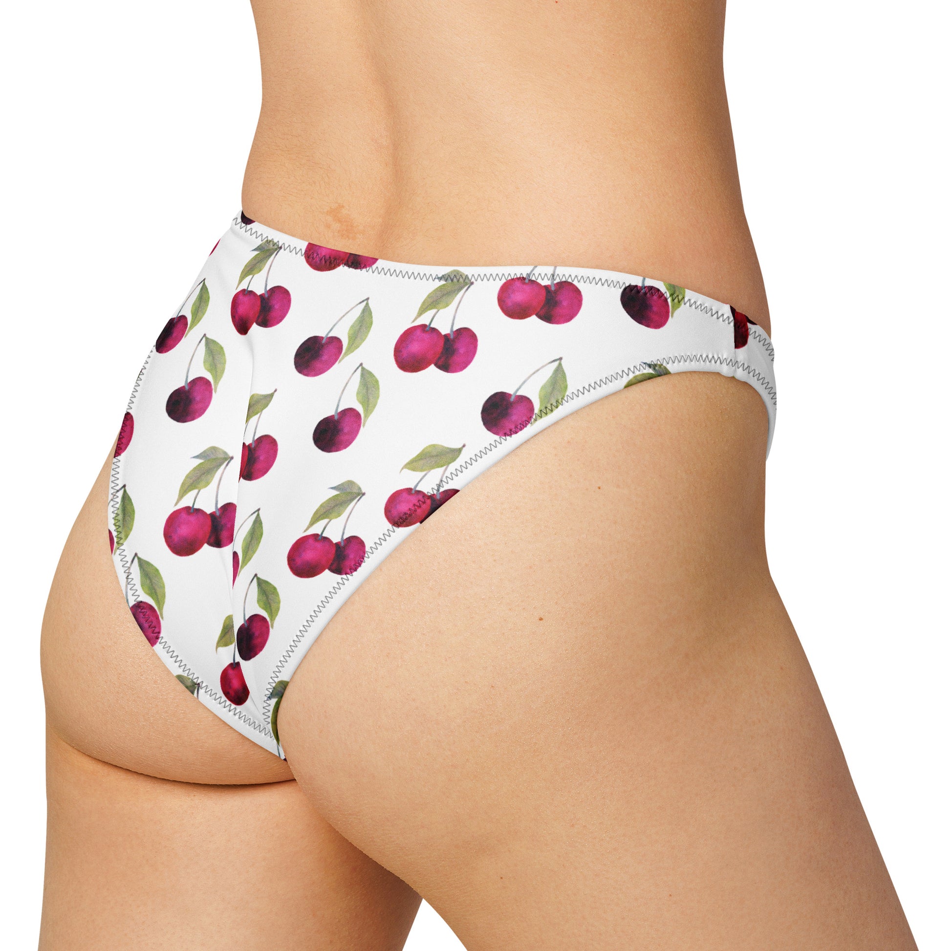 Rear view of woman wearing white bikini bottom with all-over cherries design.
