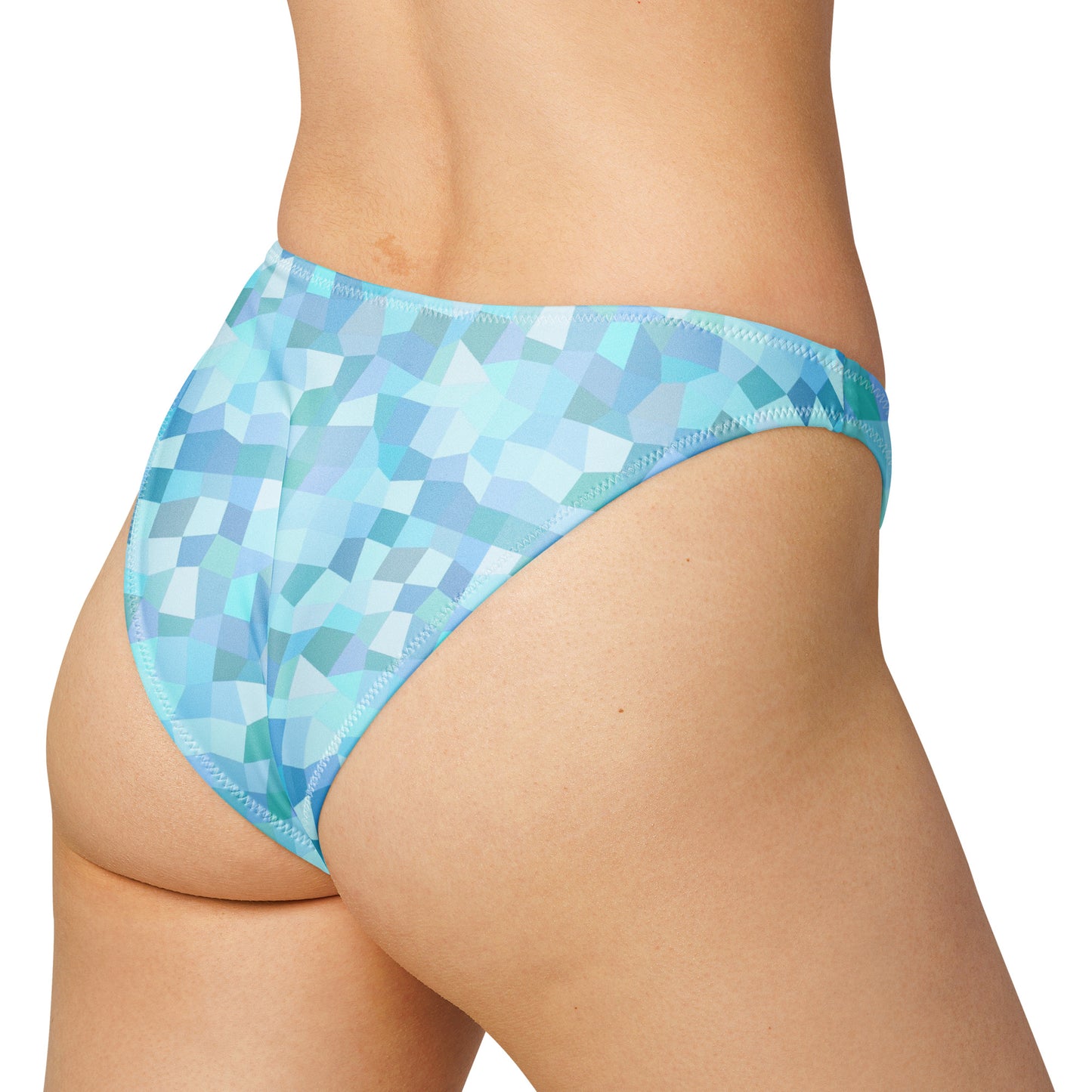 Rear view of woman wearing bikini bottom with cyan geometric pattern.