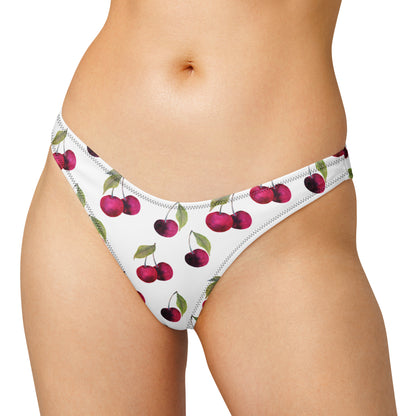 Woman wearing white bikini bottom with all-over cherries design.