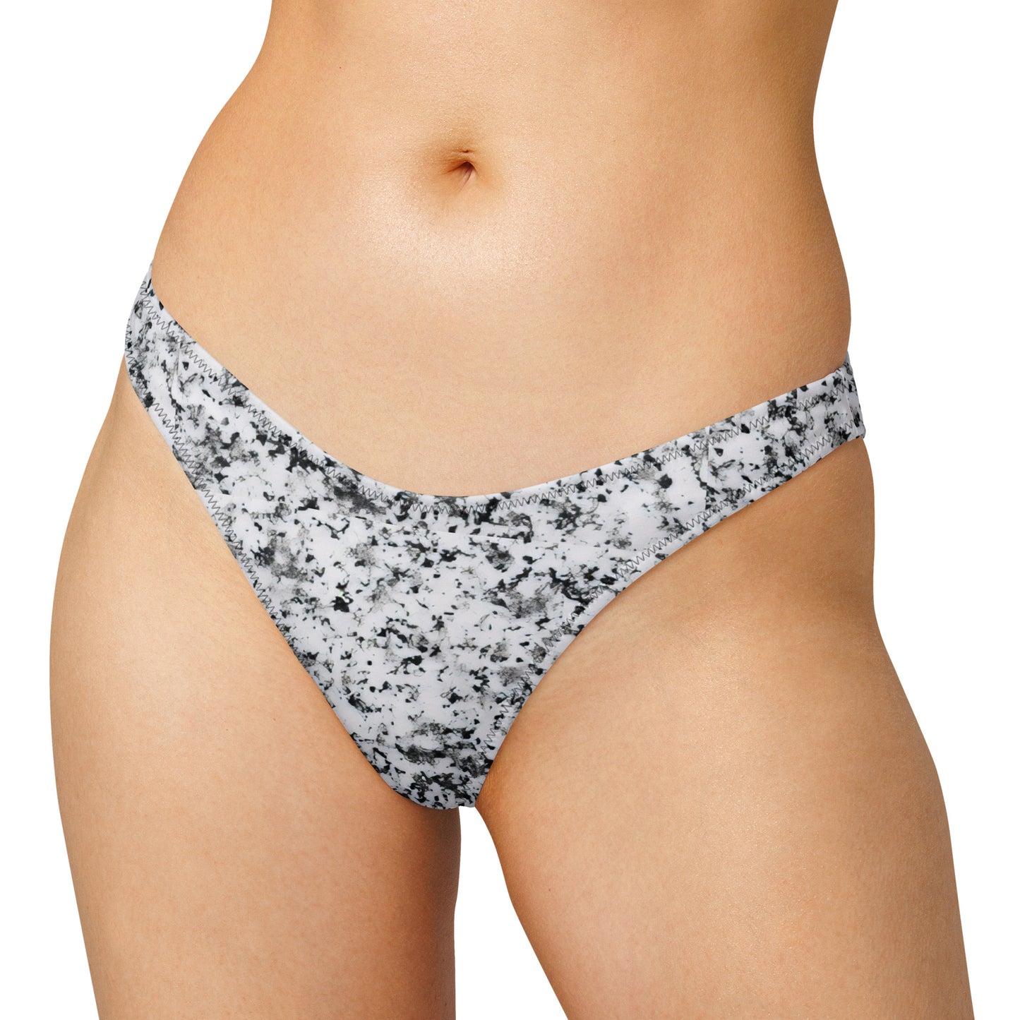 Woman wearing bikini bottom with pattern of black splotches set on white background.