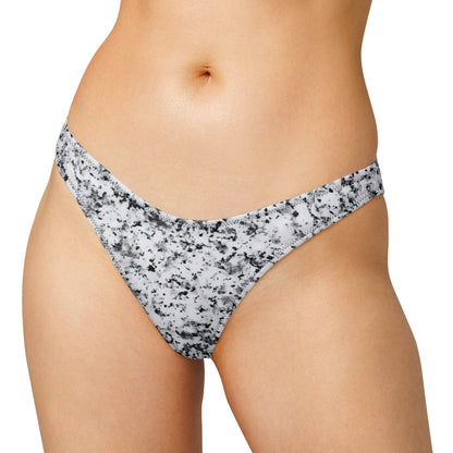 Woman wearing bikini bottom with pattern of black splotches set on white background.
