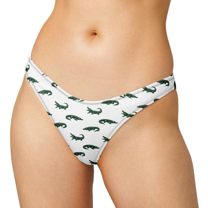 Woman wearing bikini bottom with pattern of green alligators.