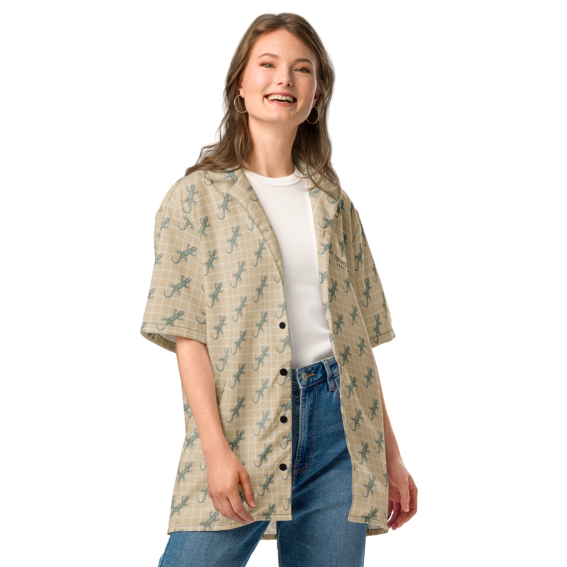 Woman wearing beige button-down shirt with pattern of green geckos.