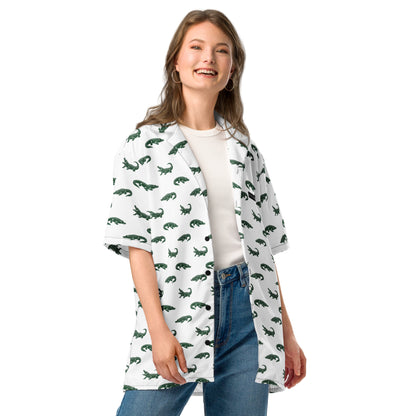 Woman wearing white button-down shirt with pattern of green alligators.