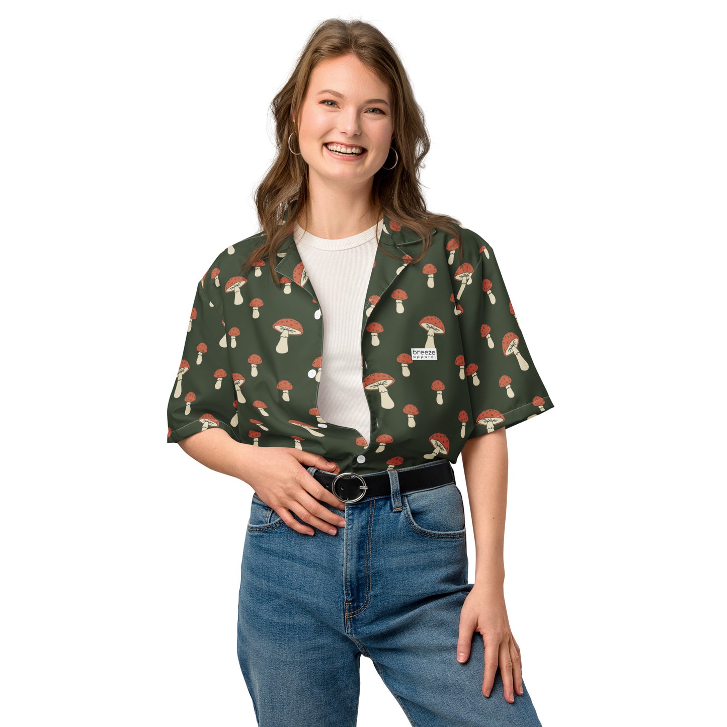 Woman wearing button-down shirt with pattern of mushrooms set on a green background.