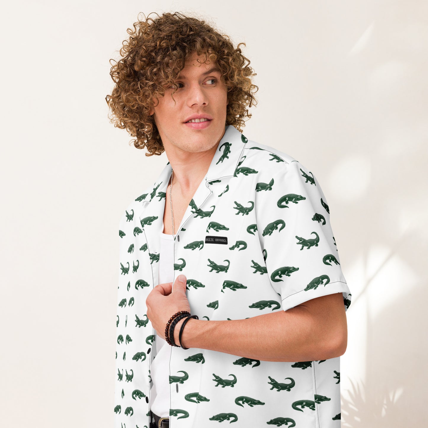 Man wearing white button-down shirt with pattern of green alligators.