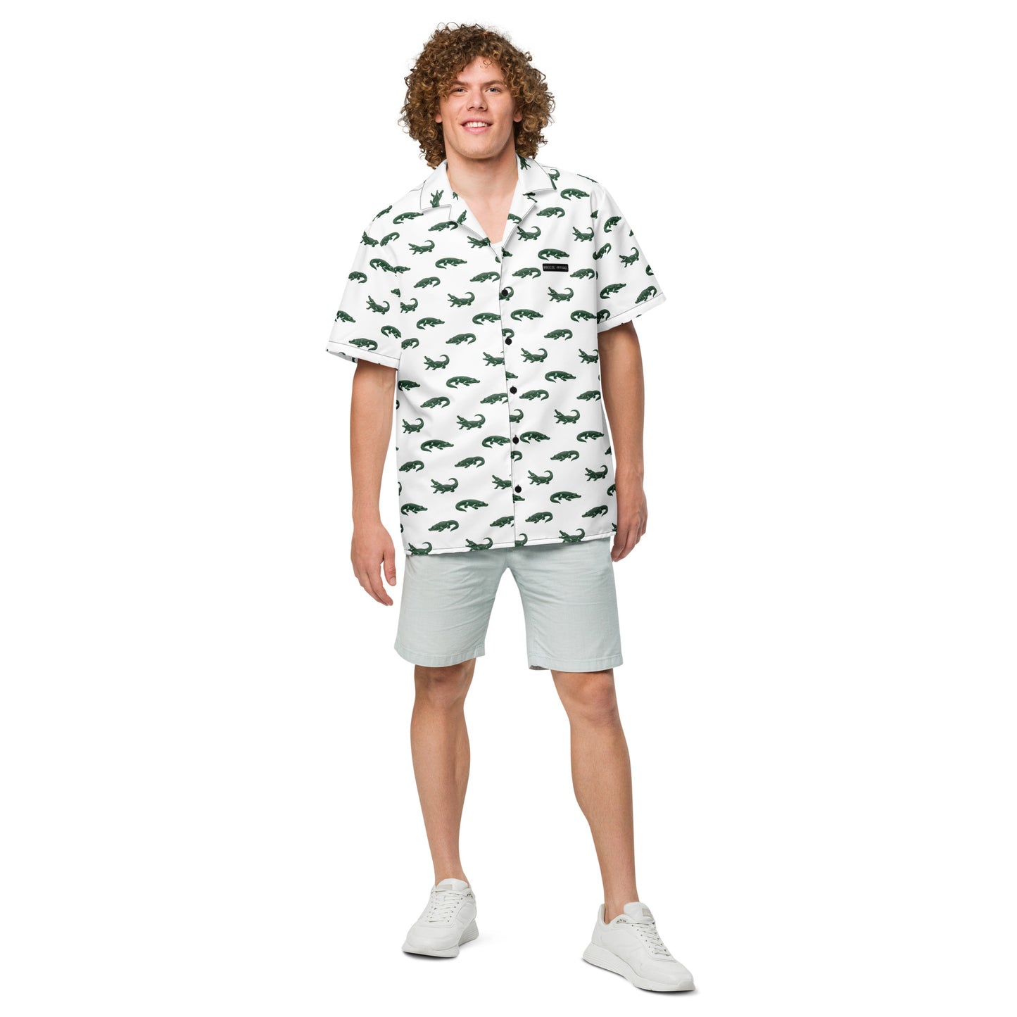 Man wearing white button-down shirt with pattern of green alligators.