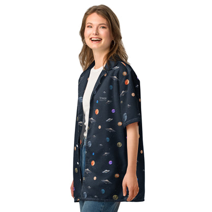 Woman wearing button-down shirt with pattern of UFOs and planets in space.