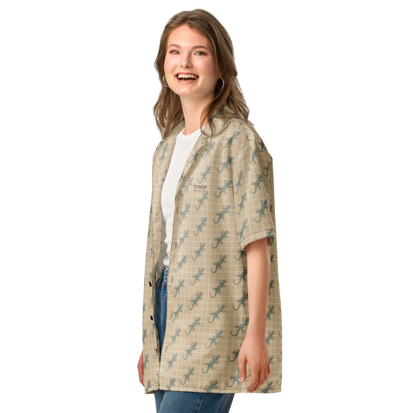 Woman wearing beige button-down shirt with pattern of green geckos.