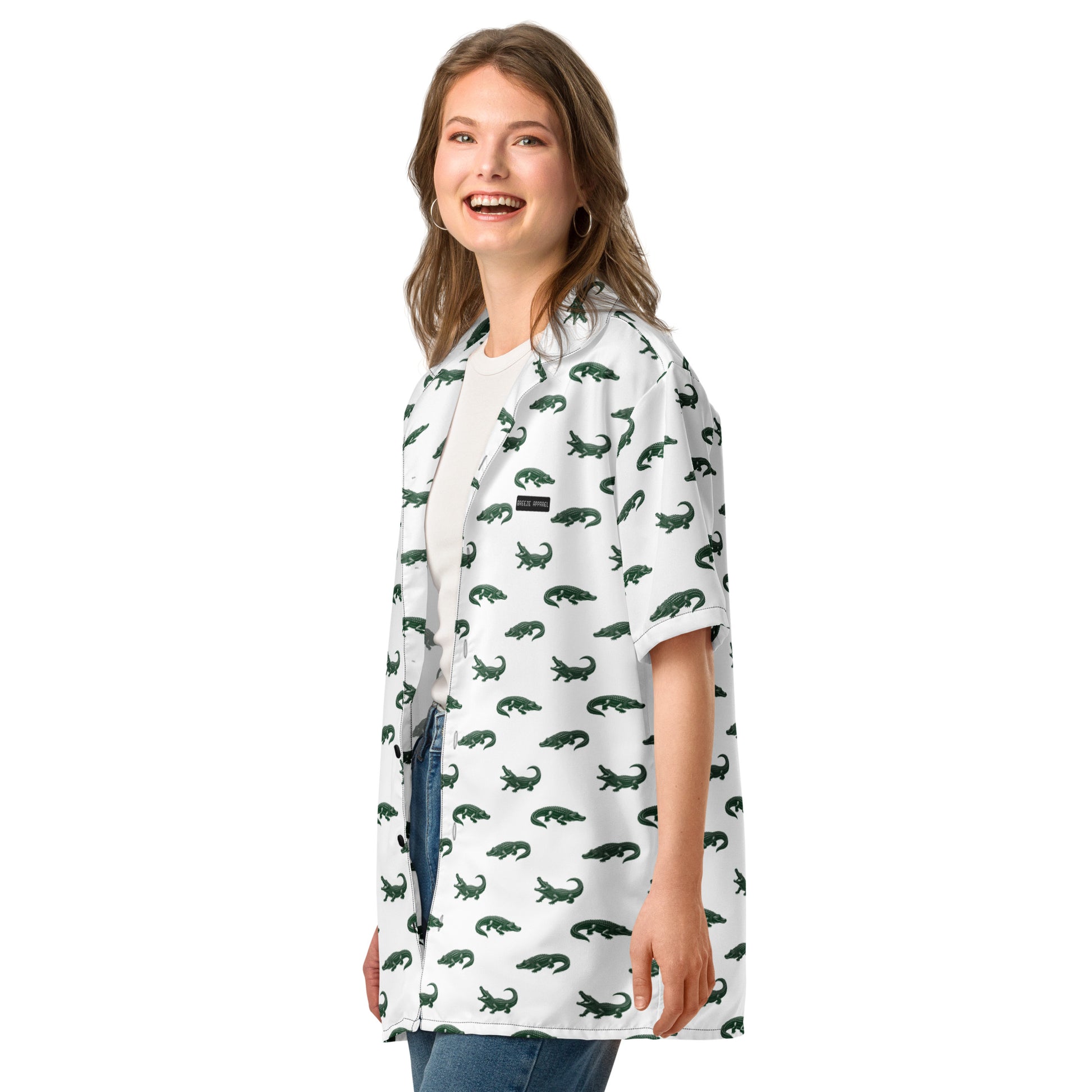 Woman wearing white button-down shirt with pattern of green alligators.