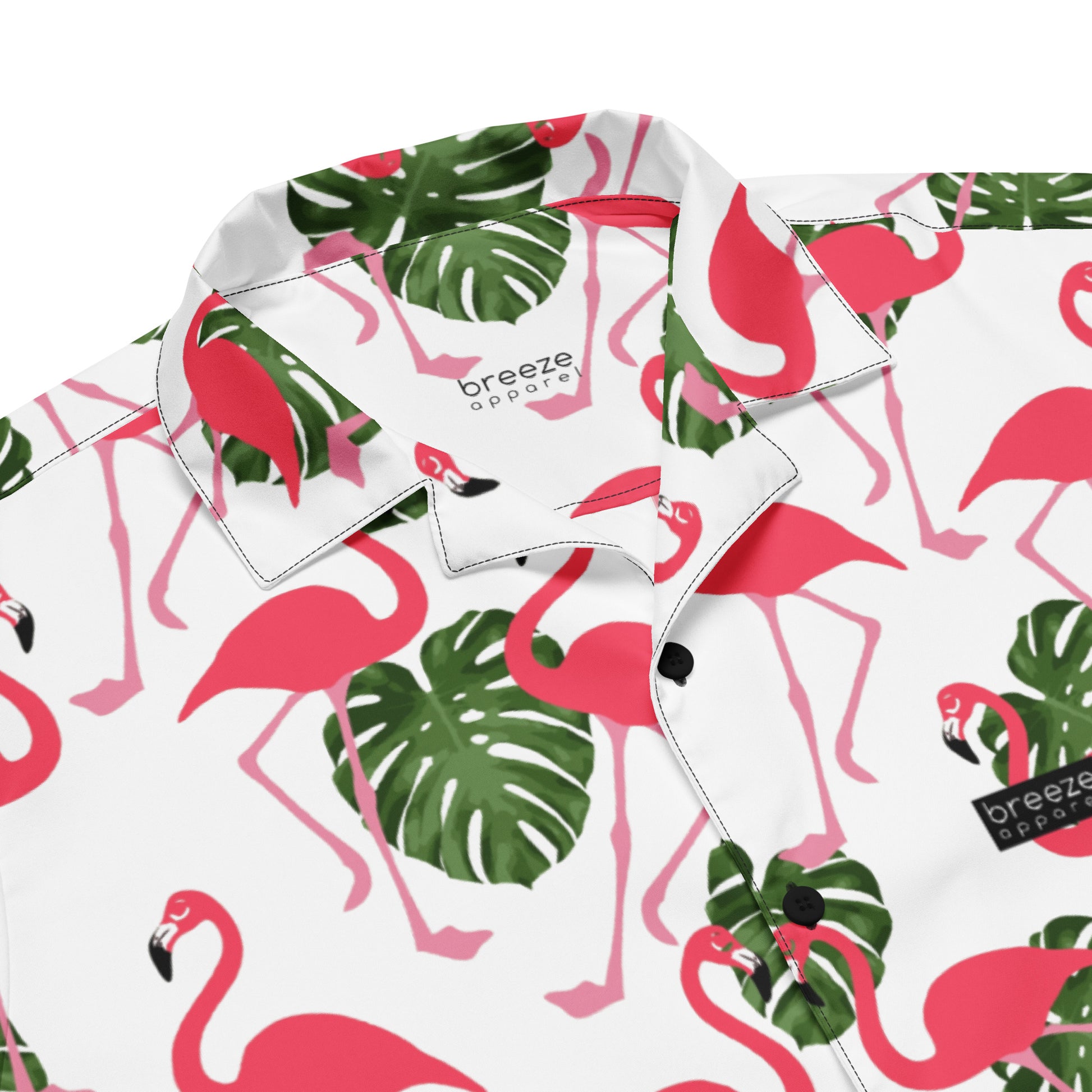 Button-down shirt with pattern of flamingos and green palm leaves set on a white background.