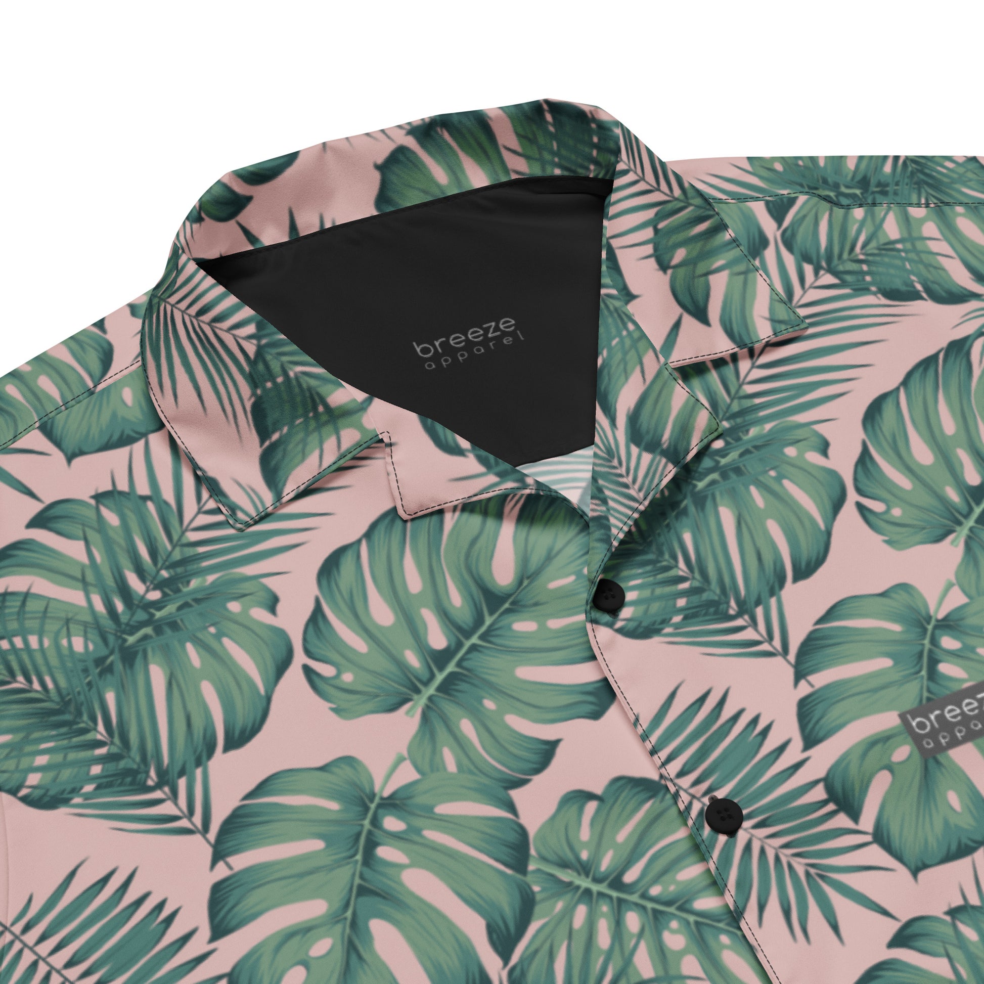 Button-down shirt with pattern of green palm leaves set on a pink background.