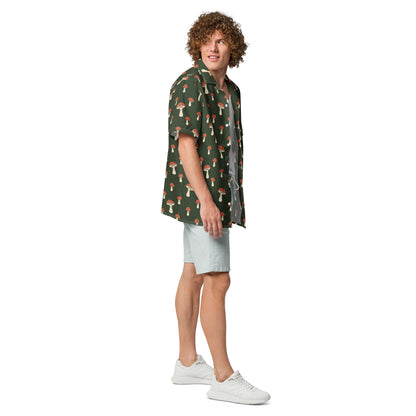 Man wearing button-down shirt with pattern of mushrooms set on a green background.
