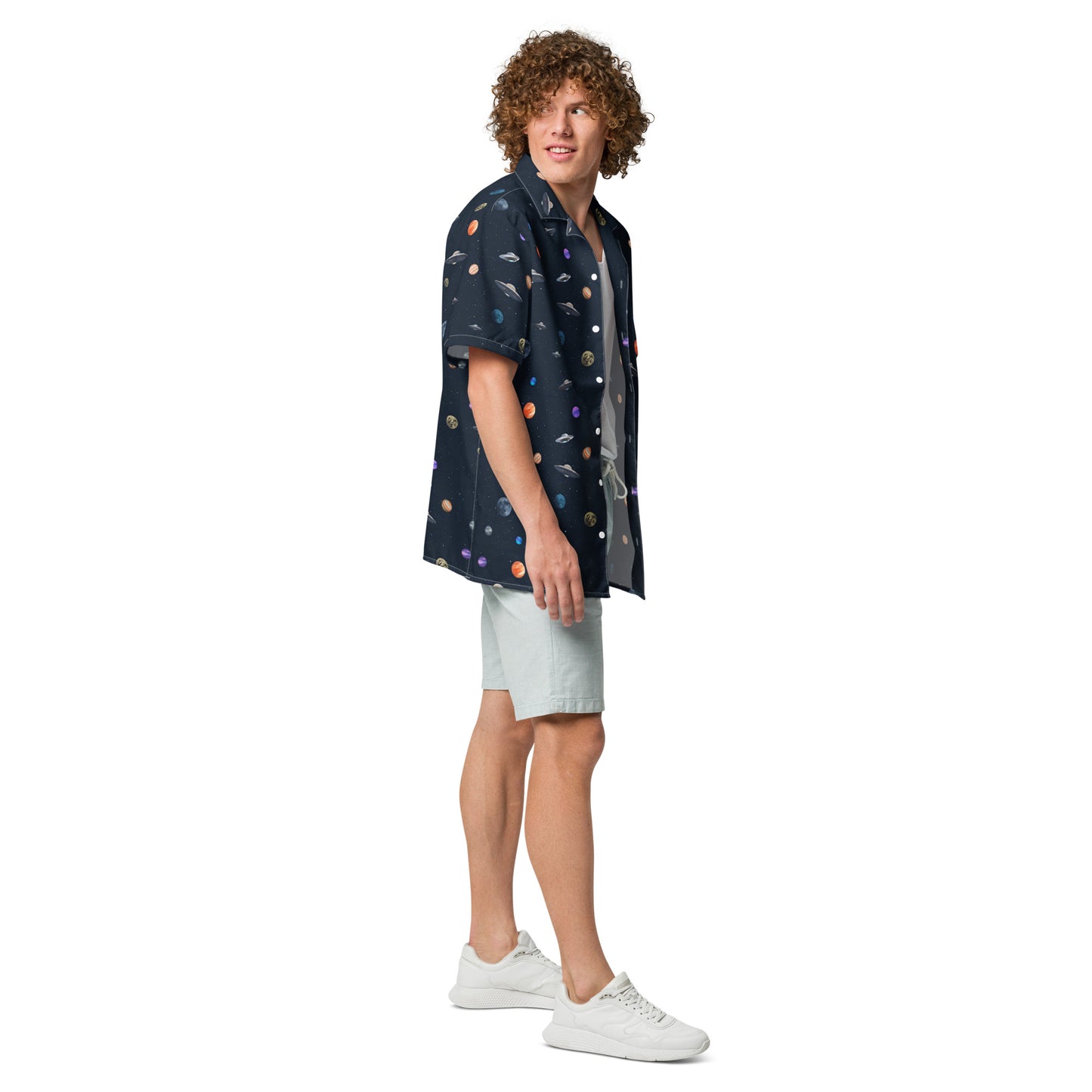Man wearing button-down shirt with pattern of UFOs and planets in space.