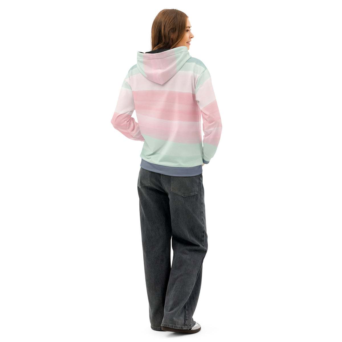 Rear view of woman wearing hoodie with colors light pastel green, shades of pink, and gray in stripes.