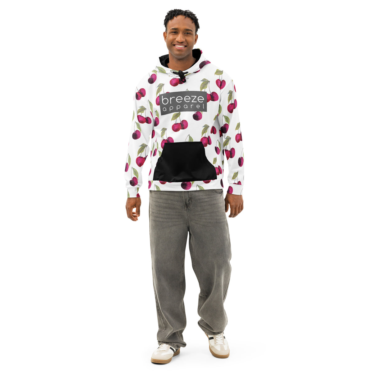 Man wearing a white hoodie with an all-over cherries design. Across the chest is a gray rectangle with 'breeze apparel' in white inside. Hood interior, drawstrings, and pocket are black.