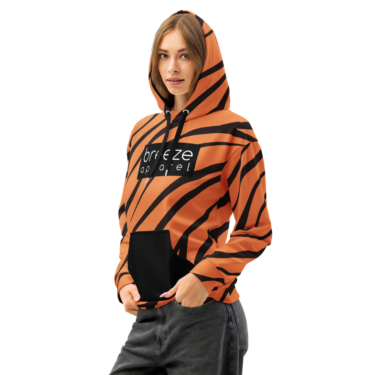 Woman wearing hoodie with a tiger-fur design, with a black pocket, black drawstrings, and a 'breeze apparel' logo consisting of white wording set in a black rectangle across the chest.